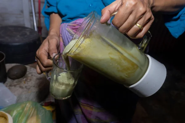 亚洲女人把鳄梨汁从搅拌机倒进杯子里 鳄梨果汁饮料 — 图库照片