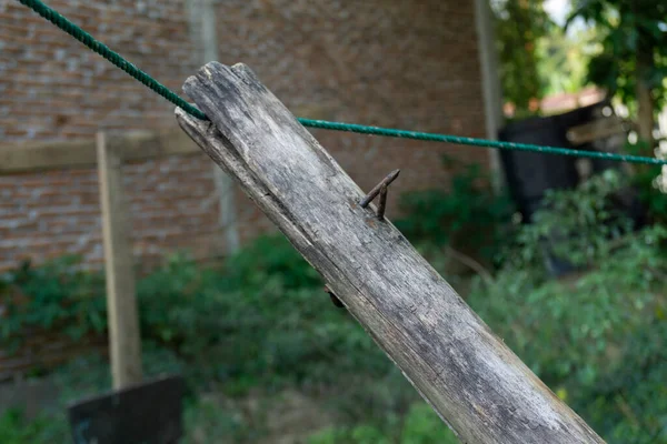 Avluda sırıklar ve çamaşır ipleri var. Yıpranmış odun ve örülmüş plastik ip.