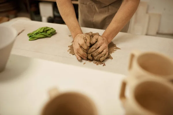 Zbliżenie Męskiego Ceramisty Fartuchu Pracującego Mokrym Kawałkiem Gliny Stole Pracowni — Zdjęcie stockowe