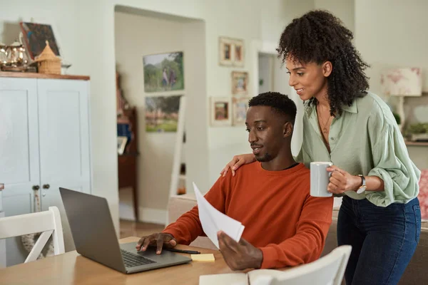 自宅のノートパソコンでオンラインバンキングをしながら 若い多人種のカップルが請求書を支払う笑顔 — ストック写真