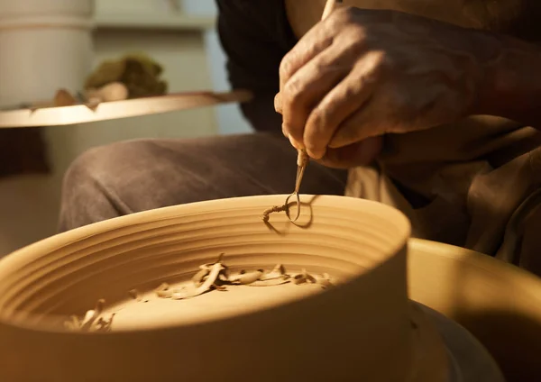 陶芸スタジオでハンドルメーカーのツールを使用して車輪に回転ボウルを形成する男性アフリカの陶器メーカーのクローズアップ — ストック写真