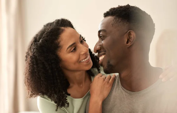 若い多人種のカップルがお互いを見て愛情を込めて笑顔で家に座っている間 — ストック写真