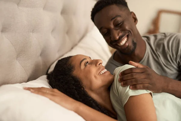 Joven Pareja Multirracial Sonriendo Mientras Despiertan Juntos Dormitorio Casa Por Imagen de stock
