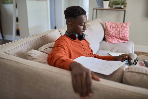 Молодий Африканський Підприємець Сидить Дивані Вітальні Читає Папери Користується Табличкою Ліцензійні Стокові Фото