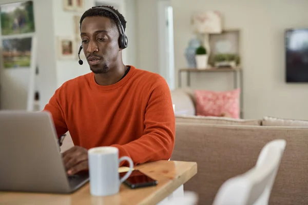 Young African Male Entrepreneur Wearing Headset Using Laptop While Working Royalty Free Stock Photos