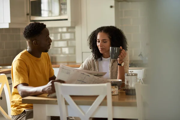 Young Multiethnic Couple Drinking Coffee Reading Newspaper Together Breakfast Kitchen — Stock Photo, Image