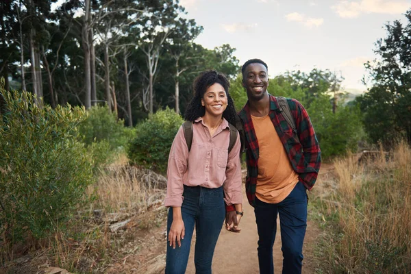 夏の険しい丘の道に沿って一緒にハイキングのために笑っている若い多民族のカップルの肖像画 — ストック写真