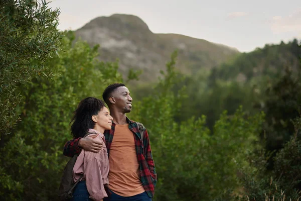 Smiling Young Multiethnic Couple Enjoying Scenic View While Hiking Together Stock Photo