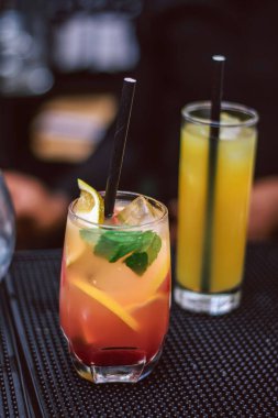 Lagos barında servis edilen limonlu kokteyl - bir bardak portakal suyu - siyah arka planda mojito kokteyli. 