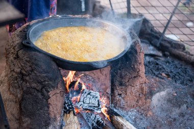 Afrikalı bir kadının geleneksel bir tencereyle Ekiti 'deki palmiye yağlı fasulye kekini kızartırken yakın plan fotoğrafı.