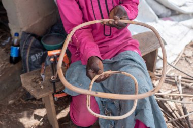 Bay Michael Ajayi, 45 yaşındaki bir zanaatkar 11 Haziran 2024 'te Ibadan, Oyo State, Nijerya' daki el sanatları atölyesinde bastonla dokuduğu sepetin ilerlemesini sunar.