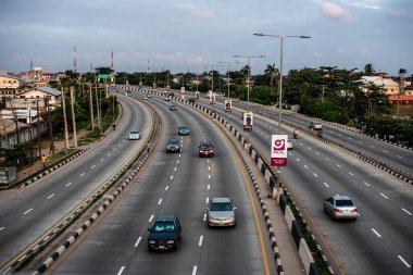 1 Eylül 2024 'te Lagos, Nijerya' nın Gbagada bölgesinde gün batımında bir otoyol boyunca hafif trafik