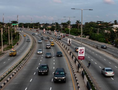 1 Eylül 2024 'te Lagos, Nijerya' nın Gbagada bölgesinde gün batımında bir otoyol boyunca hafif trafik