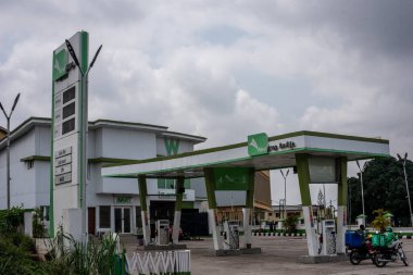 4 Eylül 2024 'te Ibadan, Oyo, Nijerya' da yakıt satmayan kapalı bir benzin istasyonunun kapısına parketmiş motosikletler. NNNPCL benzin fiyatlarına zam yapıyor, Lagos 'ta N855 / litre, Abuja' da N897 'ye satıyor.