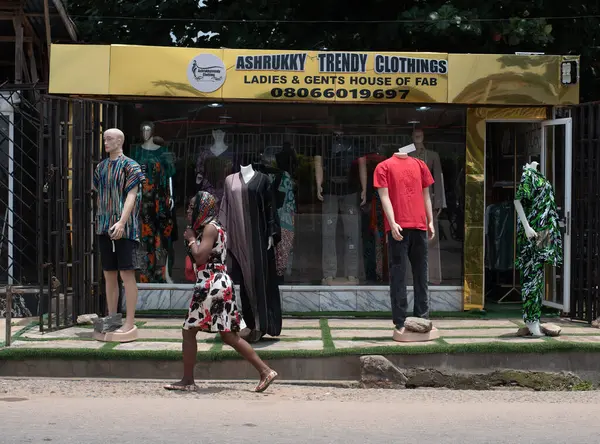 4 Eylül 2024 Çarşamba günü, Ibadan, Oyo State, Nijerya 'da bir moda mağazasının önünden geçen iki bayan....