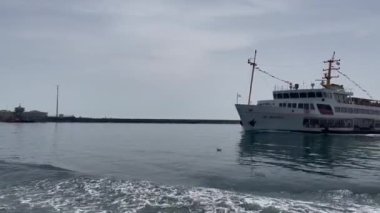 İstanbul Sehir Hatlari feribotu Avrupa tarafından Asya tarafına, arka planda deniz feneri.