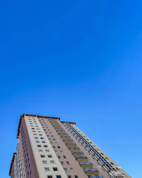 Low angle view of high-rise apartment buildings rise to the sky. Exterior view of residential buildings from below.