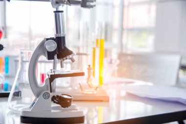 Biyoloji kimya laboratuvarında mikroskop ekipmanı. Laboratuvar masa mikrobiyolojisi ekipmanları üzerinde bilimsel deney mikroskobu. Laboratuvar arka planında kimya nesneleri. Kimya bilimsel kavramı