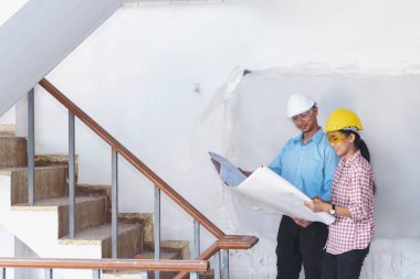 İnşaat mühendisi takım çalışması güvenlik ekibi, inşaat sahasında beyaz sarı şapkalı güvenlik ekipmanı tutuyor. Hardhat İnşaat Mühendisliği Mühendisliği Yöneticisini Koru