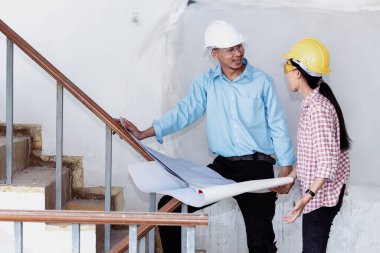 İnşaat mühendisi takım çalışması güvenlik ekibi, inşaat sahasında beyaz sarı şapkalı güvenlik ekipmanı tutuyor. Hardhat İnşaat Mühendisliği Mühendisliği Yöneticisini Koru