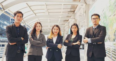 Group of business people asian team partners walking in city happy together. Leader executive men standing at modern urban city with confident teamwork. Portrait diversity businesspeople teamwork