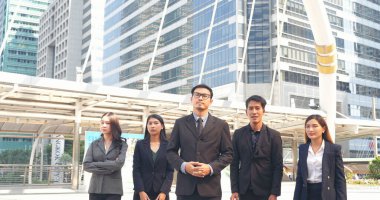 Portrait Group of businesspeople arms crossed smiling look at camera in modern city background. Happy Businessman, businesswoman teams partnership. Business people teams positive teamwork standing.