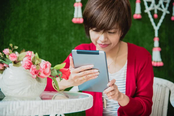 Asian woman using digital tablet shopping online, call, texting message internet technology lifestyle with smiling face. Asian woman touch smart tablet focus on hands using mobile app home office.
