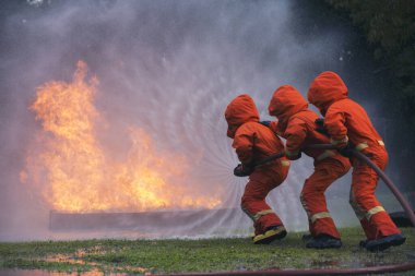 İtfaiyeciler yangın korumalı mallarla savaşıyor. İtfaiyeciler sert şapka takar, yangın operasyonundan korunmak için vücut koruma üniforması giyer. Yangın söndürücü yangın söndürme eğitimi aldım.