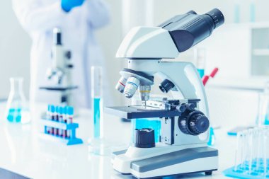 Biyoloji kimya laboratuvarında mikroskop ekipmanı. Laboratuvar masa mikrobiyolojisi ekipmanları üzerinde bilimsel deney mikroskobu. Laboratuvar arka planında kimya nesneleri. Kimya bilimsel kavramı