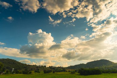 Dağ manzarasında dramatik bir gün batımı. Güzel manzara sisli tepeler alacakaranlık vakti. Mavi altın gökyüzü gün doğumu dramatik manzara dağları. Şafak vakti altın rengi alacakaranlık zamanı güneş ışığıyla bulutlu manzara
