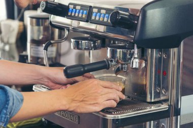 Close up hands coffee barista man make hot cup espresso shot from coffee machine. Cappuccino with milk in italian coffee shop cafe. Close up hands of barista use machine make black drinking hot cup