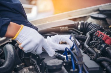 Tamirci araba tamirhanesini kapatırken araba tamircisini de eline aldı. Makineli araç mekanik servisini tamir eden adam elleri. Araç kaputu otomobili kontrol ediyor. Araç bakım mühendisi.