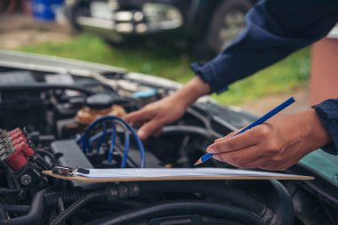 Tamirci araba tamirhanesini kapatırken araba tamircisini de eline aldı. Makineli araç mekanik servisini tamir eden adam elleri. Araç kaputu otomobili kontrol ediyor. Araç bakım mühendisi.