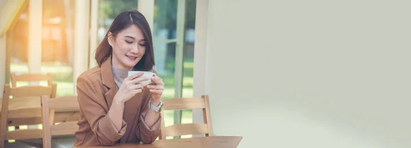 Banner Asian Woman drink black coffee hand holding cup at green garden cafe. Young woman smile face love coffee. Panorama Beauty woman drinking black tea in coffee shop holding cup with copy space