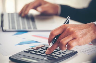 Yakın plan Asyalı işadamına hesap numarasını, iş planlama raporunu, Asyalı iş adamının ellerini hesap makinesi kullanarak hesap makinesini, vergi faturasını verdi. Vergi denetimi finans kavramı