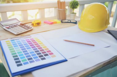 İnşaat mühendisi, ofis masası mimar işyeri. Mühendis, üzerinde metre, plan ve inşaat başlığı olan nesneler çiziyor. Tasarımcı Nesneler ahşap masada çalışma alanı çiziyor.