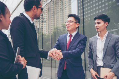 Diversity Business Partner meeting trust in teamwork and partnership businessman, businesswoman talking together in modern city. Asian coworker team meeting with Business People Working Together Team