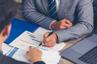 İki iş adamı büro masasında çalışıyor. İş stratejisi grafiği çizelgesi olan takım çalışması ortakları takımı, bilgi veri finans raporu. Takım ortağı pazarlama planlaması finans üstünlüğü istatistik raporu