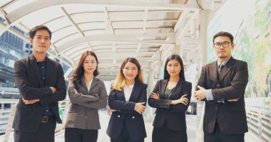 Group of business people asian team partners walking in city happy together. Leader executive men standing at modern urban city with confident teamwork. Portrait diversity businesspeople teamwork