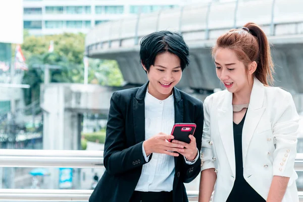 Business Woman Partner talk, meeting team Partnership in modern city together. Diversity Asian Business Partner online meeting trust teamwork. Asian Two Business people teams meeting outdoor in city.