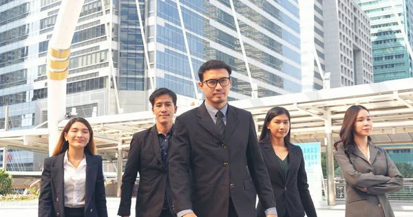 Portrait Group of businesspeople arms crossed smiling look at camera in modern city background. Happy Businessman, businesswoman teams partnership. Business people teams positive teamwork standing.