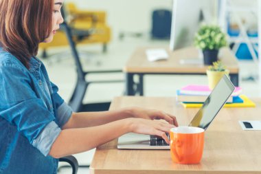 Ev ofis masasında dizüstü bilgisayar kullanan Asyalı kadın serbest yazar. Finansal grafik çizelgesi okuyan kadın pazarlama verilerini analiz ediyor. Ofiste çalışan Asyalı kadınlar, iş konuları, kahve fincanları.