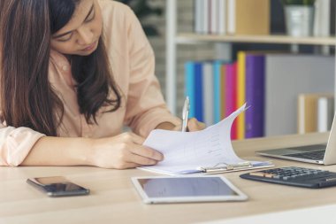 Ev ofis masasında dizüstü bilgisayar kullanan Asyalı kadın serbest yazar. Finansal grafik çizelgesi okuyan kadın pazarlama verilerini analiz ediyor. Ofiste çalışan Asyalı kadınlar, iş konuları, kahve fincanları.