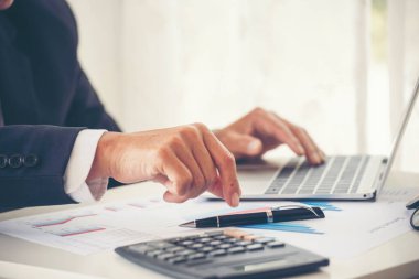 Yakın plan Asyalı işadamına hesap numarasını, iş planlama raporunu, Asyalı iş adamının ellerini hesap makinesi kullanarak hesap makinesini, vergi faturasını verdi. Vergi denetimi finans kavramı