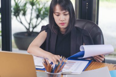 Ev ofis masasında dizüstü bilgisayar kullanan Asyalı kadın serbest yazar. Finansal grafik çizelgesi okuyan kadın pazarlama verilerini analiz ediyor. Ofiste çalışan Asyalı kadınlar, iş konuları, kahve fincanları.