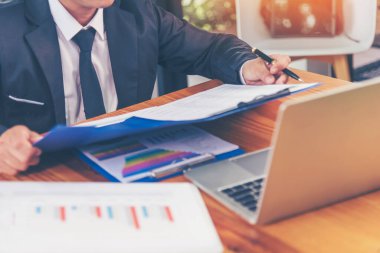 Yakından çalışan işadamları ofis masasında dizüstü bilgisayar finansmanı iş belgelerini kullanarak rapor tablosu okuyorlar. Adam elleri klavye yazın ofis nota kontrol mali grafik grafiği