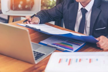 Yakından çalışan işadamları ofis masasında dizüstü bilgisayar finansmanı iş belgelerini kullanarak rapor tablosu okuyorlar. Adam elleri klavye yazın ofis nota kontrol mali grafik grafiği