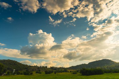 Dağ manzarasında dramatik bir gün batımı. Güzel manzara sisli tepeler alacakaranlık vakti. Mavi altın gökyüzü gün doğumu dramatik manzara dağları. Şafak vakti altın rengi alacakaranlık zamanı güneş ışığıyla bulutlu manzara