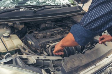 Tamirci araba tamirhanesini kapatırken araba tamircisini de eline aldı. Makineli araç mekanik servisini tamir eden adam elleri. Araç kaputu otomobili kontrol ediyor. Araç bakım mühendisi.