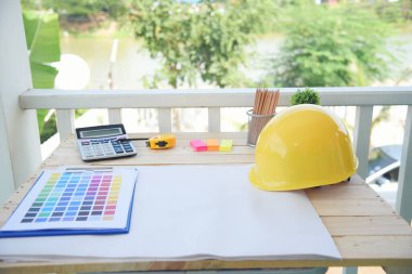 İnşaat mühendisi, ofis masası mimar işyeri. Mühendis, üzerinde metre, plan ve inşaat başlığı olan nesneler çiziyor. Tasarımcı Nesneler ahşap masada çalışma alanı çiziyor.